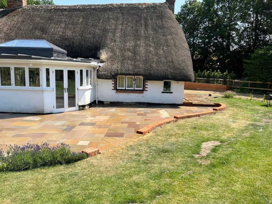 Thatched cottage with sandstone patio and curved brick edging β Green's Brickwork, Hampshire