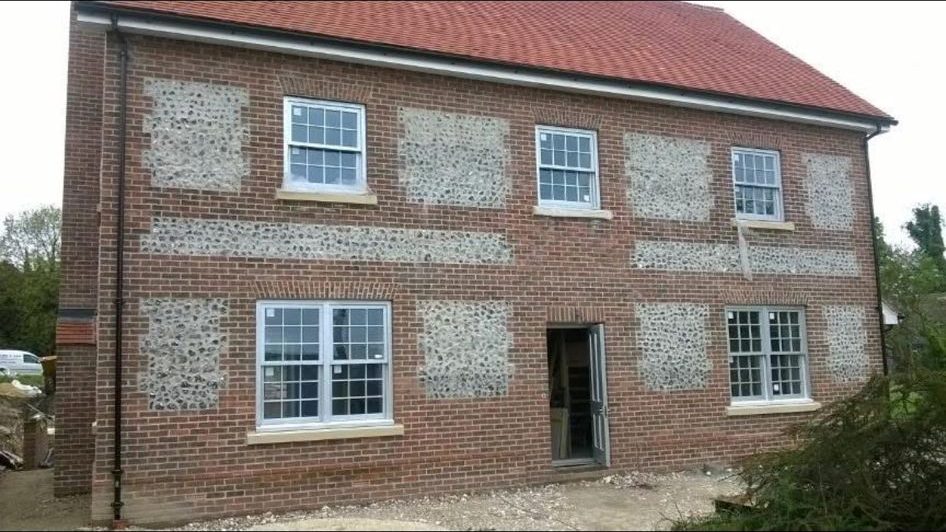 Two-storey new build house with red brickwork and traditional flint panels β Green's Brickwork, Hampshire