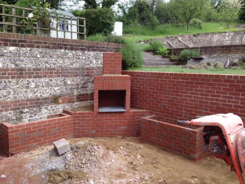 Garden brickwork and flint work boundary wall with built-in outdoor fireplace β Green's Brickwork, Hampshire